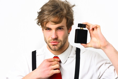 Bearded man, short beard. Caucasian stylish man posing with perfume in shirt and suspenders in...