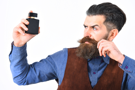 bearded man, long beard, brutal caucasian hipster with moustache holding perfume with serious face isolated on white backgroundの写真素材