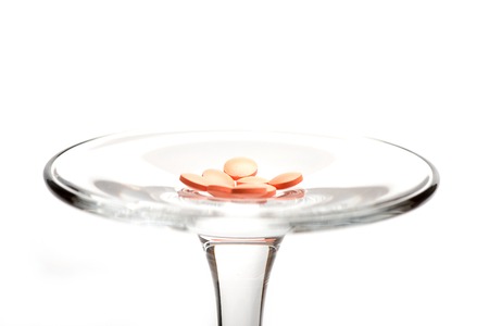 Red pills, tablets on glass stem, isolated on white backgroundの写真素材