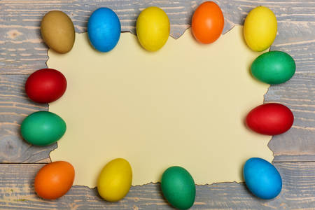 set of colorful eggs on burnt paper on grey vintage wooden background. Happy Easter concept, copy spaceの写真素材
