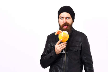 Bearded man, long beard. Brutal caucasian satisfied hipster with moustache holding glass of alcoholic beverage or fresh cocktail in rock black style isolated on white studio backgroundの写真素材