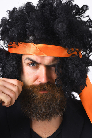 Bearded man, long beard. Brutal caucasian hipster with moustache have suit and black curly tie-tied afro wig isolated on white studio backgroundの写真素材