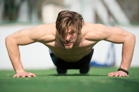 muscular man doing push ups, male athlete exercising push up sunny outdoor, fit shirtless guy, fitness model exercise outside. healthy lifestyle concept, summer activity and sportの写真素材