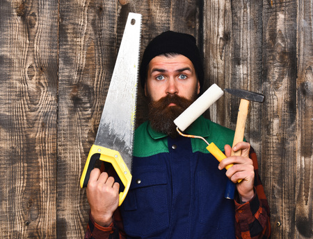 bearded man, long beard, brutal caucasian hipster with moustache holding various building tools:...