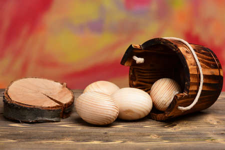 tree stump near wood beige eggs in wooden bucket or pail, happy easter concept, healthy food, farming and agriculture, future life and childhoodの写真素材