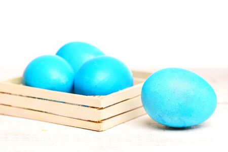 robin egg or eggshell blue, traditional easter food painted in bright color in wooden box isolated on white background, future life, greeting and celebrationの写真素材
