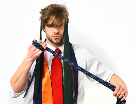 Bearded man, short beard. Caucasian bearded serious sexy macho with moustache holding colorful ties wearing white shirt with suspenders and red tie isolated on white backgroundの写真素材