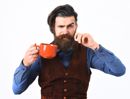 bearded man, long beard, brutal caucasian hipster with moustache holding mug or cup with coffee, tea with serious face isolated on white backgroundの写真素材