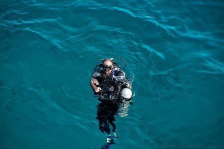 Hurghada, Egypt - February 24, 2017: underwater, snorkeling diver, man in wetsuit with snorkel, scuba, aqualung, mask swimming in sea or ocean on sunny day on blue background. Idyllic summer vacationのeditorial素材