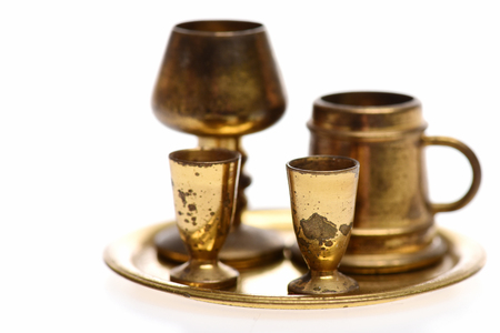 set of antique chalice, goblets and beer pint on golden tray isolated on white background, selective focusの写真素材