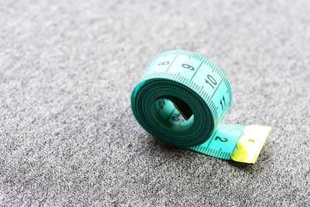 Roll of light blue measuring tape with golden end on grey background, copy spaceの写真素材