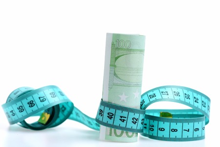 Beauty requires sacrifice concept, measuring tape with euro isolated on white backgroundの写真素材