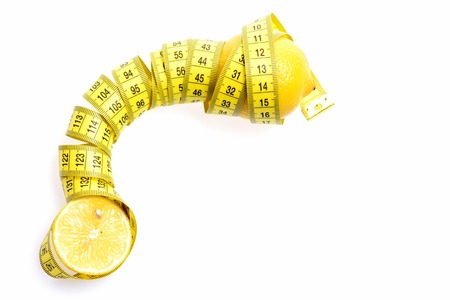 Health and diet concept. Tape-measure twined around lemon isolated on white background, copy spaceの写真素材