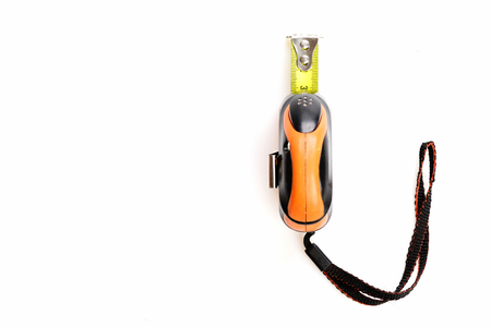 Tape measure in yellow, orange and black colors isolated on white background with copy space. Concept of tool for carpentry or constructionの写真素材