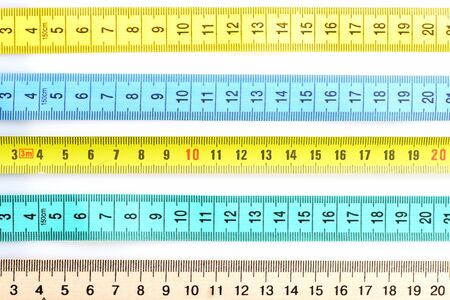 Rulers of different materials lying in parallel, isolated on white background. Measuring and...
