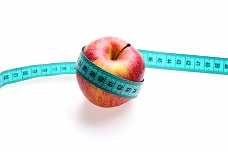 Concept of vitamin diet and healthy food: red ripe apple tied with cyan tape for measuring, isolated...