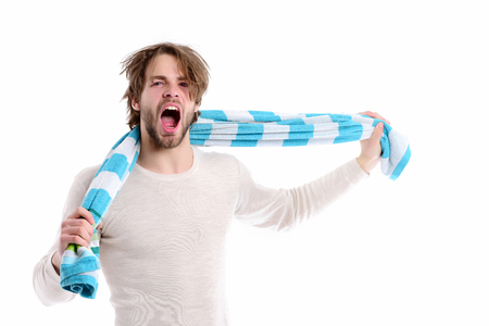 Bearded macho waking up, yawning and using his white blue striped towel, isolated on white background, copy space. Shower time and good morning conceptの写真素材