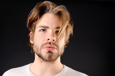 Sexy macho with short beard, moustache and fair hair wearing white tshirt and looking ahead, isolated on black backgroundの写真素材