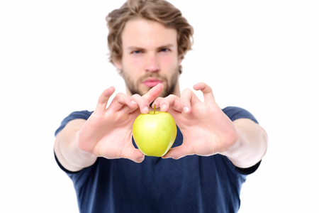 Green juicy apple in sexy caucasian males hands isolated on white background, defocused. Concept of vegetarianism and healthy lifestyleの写真素材