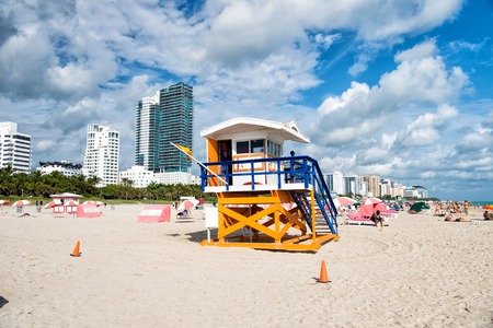 Miami, USA - January 10, 2016: Miami beach or south beach. open wooden tower with lifeguard man patrolling sea beach, on sunny with high buildings and white clouds on blue sky. Summer vacation.のeditorial素材