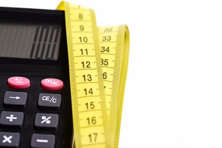 Calculator with number 100 with yellow measuring tape folded nearby isolated on white background. Concept of counting and size measurementの写真素材
