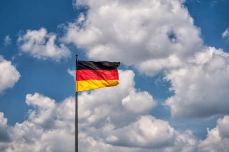 German flag on a background of the blue sky with cloudsの写真素材