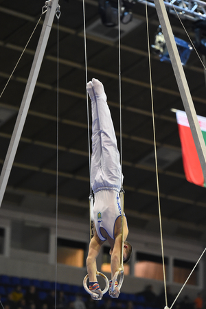 Kyiv. Ukraine-April 1, 2017 : Male gymnast performing on stationary gymnasic rings during Stella Zakharova Artistic Gymnastics Cupのeditorial素材