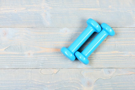 blue dumbbells on grey vintage wooden background, copy space with gym equipment conceptの写真素材