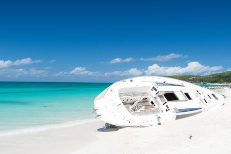 Boat on beach with white sand, turquoise sea or ocean and blue sky on sunny day on natural background. Idyllic tropical landscape. Summer vacation and holidays. Travel, traveling on waterの写真素材