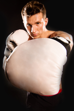 Man with muscular body. Boxer with bare chest. Athletic bodybuilder pose in pants. Sport and workout. Gladiator or atlant in boxing gloves.の写真素材