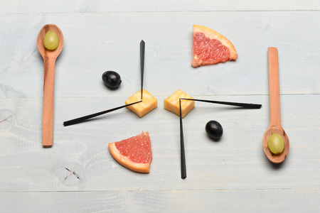 Composition of grapes and grapefruit. Art and healthy food concept. Tasty snack with cheese and summer fruit, top view. Food on vintage background. Wooden spoons, skewers and food making picture.の写真素材