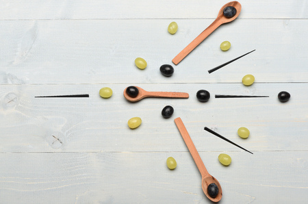 Wooden spoons with grapes. Summer fruit on vintage background. Art and healthy food concept. Composition of white and black grapes and black skewers, top view.の写真素材