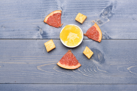 Composition of marble cheese, grapefruit and honey. Delicious snack with cheese and citrus, top view. Gourmet food on vintage background. Art and healthy food concept.の写真素材