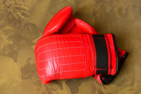 Pair of leather boxing sportswear. Boxing gloves in red color. Knock out and strong boxers punch concept. Sport equipment on beige pattern background, top viewの写真素材