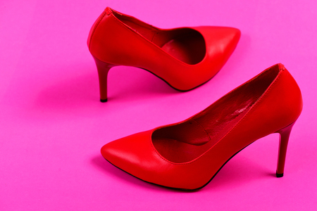 Pair of elegant female shoes, closeup. Accessories on pink background. Formal high heel footwear. Fashion and beauty concept. Female shoes in red color.の写真素材