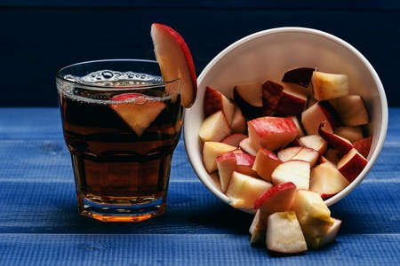 set of glass with juice and dish with pieces of apple on blue vintage wooden background, side viewの写真素材