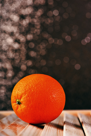 fresh orange on brown wooden table, sparkling studio background, side view, copy spaceの写真素材