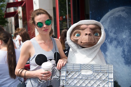 Berlin, Germany - May 31, 2017: woman posing with alien figure on sunny summer day on city street. Girl and humanoid. Urban advertising conceptのeditorial素材