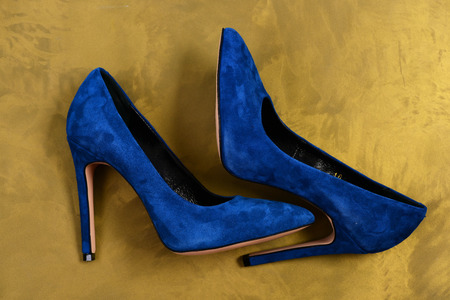 Female shoes in dark blue color. Pair of suede formal footwear, top view. Blue high heel shoes on dirty yellow background. Fashion and beauty conceptの写真素材