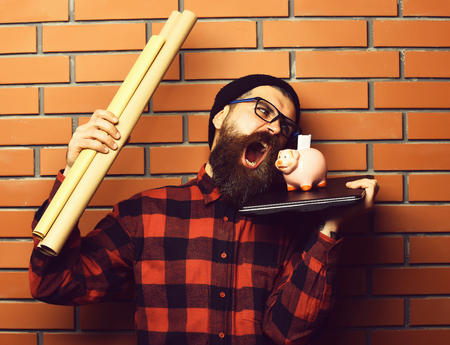 Bearded man, long beard. Brutal caucasian shouting unshaven hipster holding craft paper rolls, piggy...