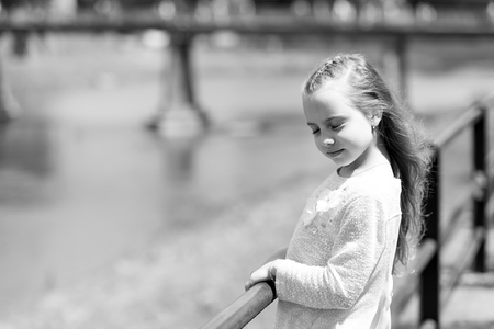 Portrait of a lovely little happy cute princess girl with long blonde curly hair at summer sunny dayの写真素材