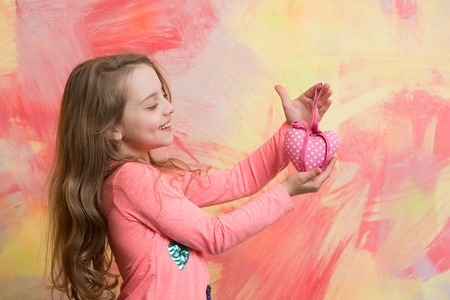 Small girl with love heart. valentines day holiday and party celebration. Child girl on colorful background. kid with decorative love heart. Childhood and happiness.の写真素材