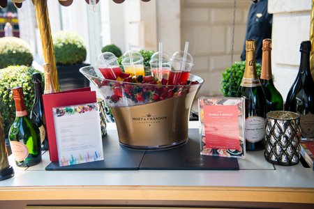 Paris, France - June 01, 2017: bar counter outdoors on building background. Menu, champagne bottles, fresh berries on ice and coctails on table. Buffet, brunch, luxury hotel concept.のeditorial素材