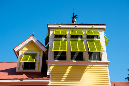 House with open yellow window shutters with pineapple on terracotta roof on sunny day on blue sky in Nassau, Bahamas. Architecture, structure, design. Summer vacation concept, Hotel atlantisのeditorial素材