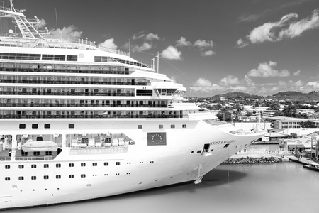 St. John, Antigua - March 05, 2016: beautiful large cruise ship, big white passenger boat, luxury modern Costa Magica vehicle at moorage in sea port, pier on summer blue cloudy sky. summer vacationのeditorial素材
