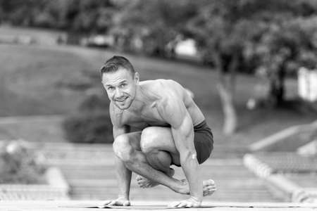 handsome Athletic man doing yoga asanas in the parkの写真素材