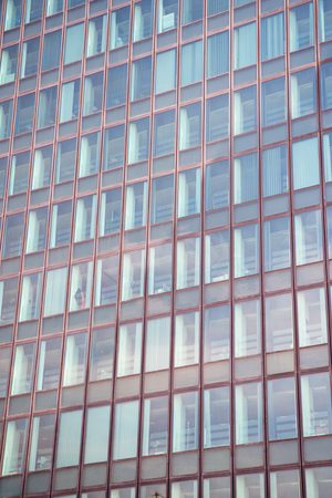 Glass windows of office building exterior in paris, france on grey facade wall background.
