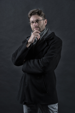 Business, vision, solution concept. Man businessman think in glasses on bearded face in black coat. Fashion, eyewear, accessory. Eyesight correction, eye care, health, vintage filterの写真素材