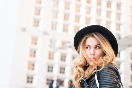 Girl flirt with sensual face, long hair, black hat in la defense, paris. Fashion, beauty, look. Vacation, travel, wanderlust. girl fashionの写真素材