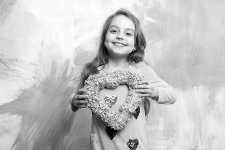 girl on smiling happy child with pink heart as love holiday of valentines day on colorful background, copy spaceの写真素材
